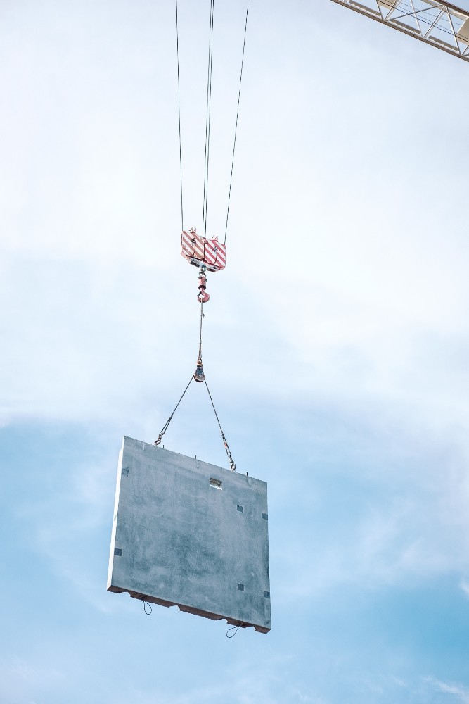 Crane holding concrete over construction site