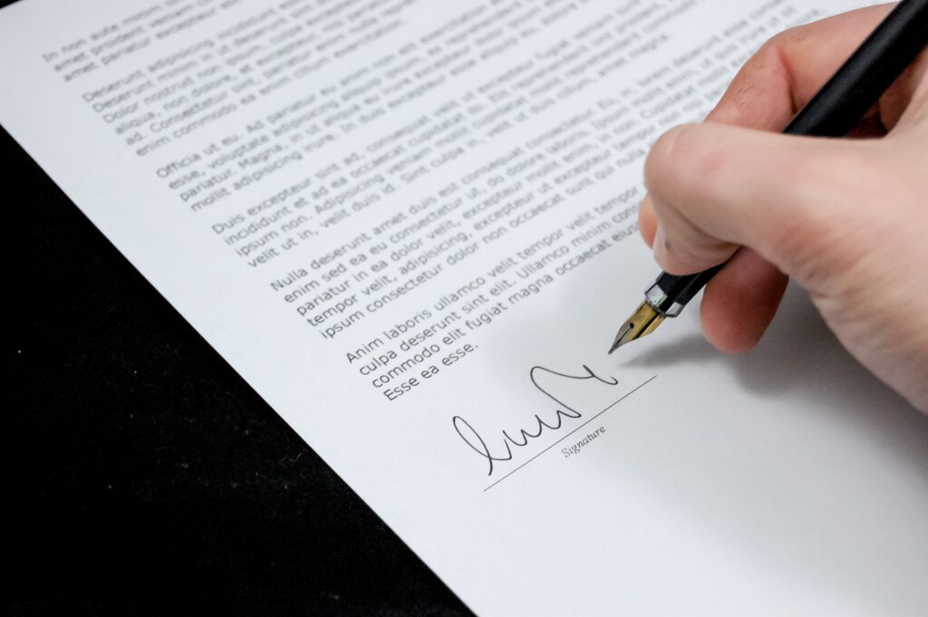 Signing a legal document in black ink.