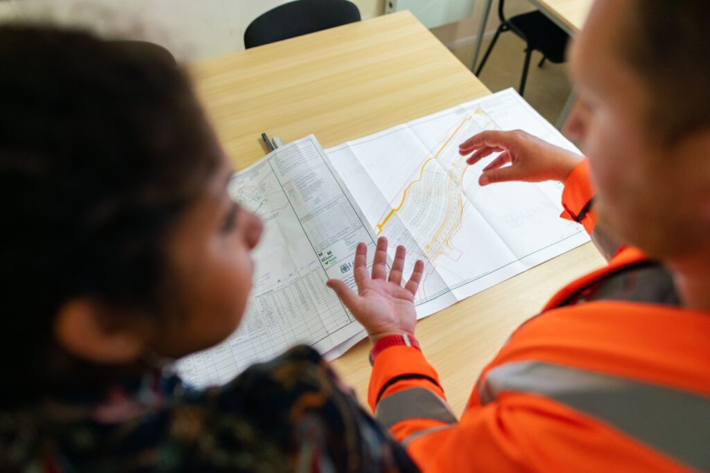 two people walking through construction plans